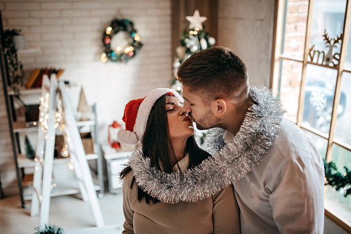Lovely couple in Christmas spirit, kissing and sharing love