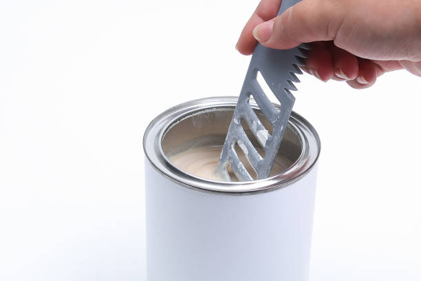 istock A man stirring white paint in can on white background. Renovation concept. 1278506636