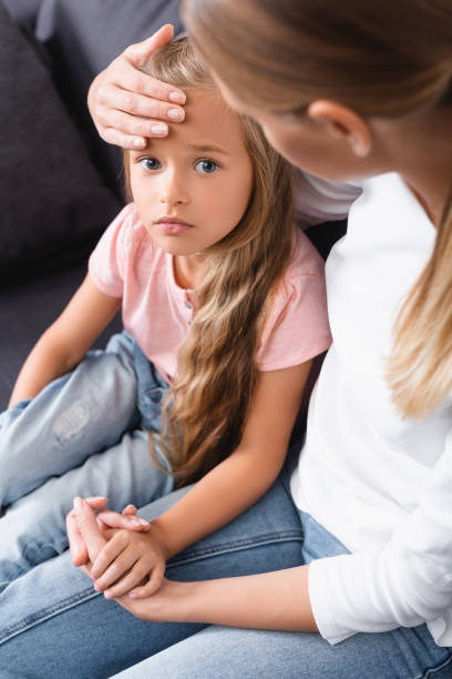 istock Selective focus of diseased kid looking at camera while holding mother hand at home 1278506992