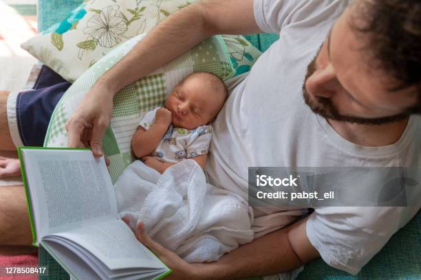 Father Reading Paper Book With Baby On Lap Stock Photo - Download Image Now - Paternity Leave, Baby - Human Age, Father