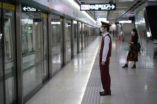 Wuhan/China-Oct.2020: working staff and passenger in face mask to prevent coronavirus, standing in subway platform