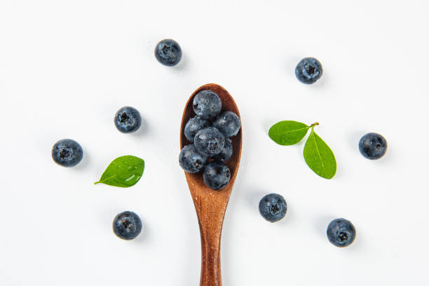 istock blueberry in a wooden spoon on white background 1278514321