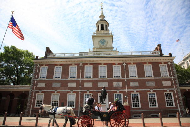 Tourist in Horse drawn carriage visiting  Independence Hall with Bronze sculpture of George Washington in Philadelphia Pennsylvania, USA stock photo