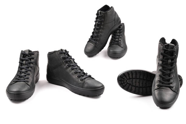 istock men's black leather shoes and a black camera on a black background. Copy space. 1278529675