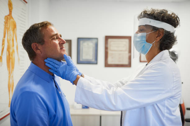 A female doctor with protective work wear doing a  thyroid gland control. Medical office
A female doctor with protective work wear doing a  thyroid gland control. thyroid gland stock pictures, royalty-free photos & images