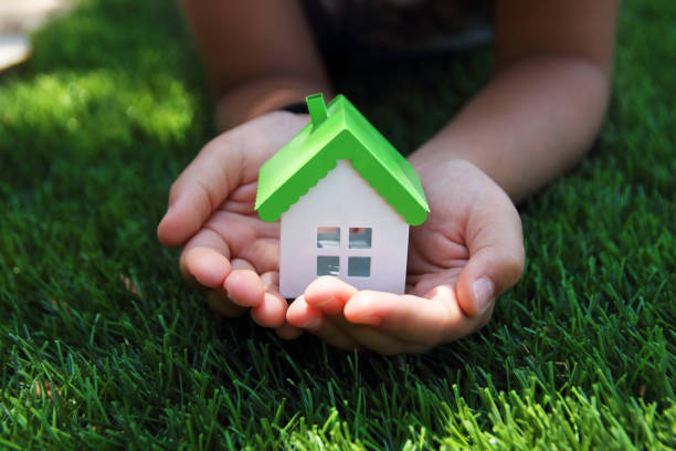 istock Child holding miniature house on garden 1278538438