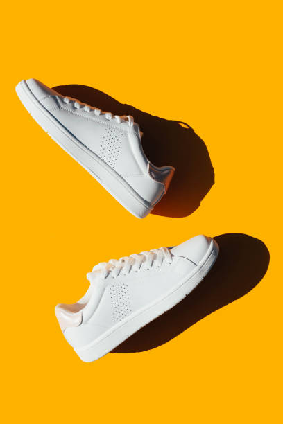 istock White sneakers on an orange background with hard shadows. 1278539307