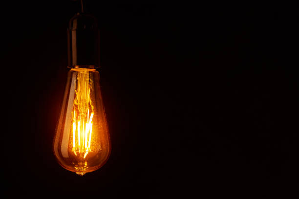 istock Vintage light bulb on black background, copy space. Glowing edison bulb 1278542314