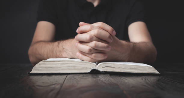 istock Caucasian man praying in the dark room. 1278544458