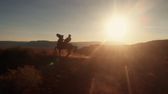 Young Teenage Native American Navajo Boy Riding his Horse Bareback in the Navajo Reservation Near Monument Valley Tribal Park in Northern Arizona at Dusk in the Summer