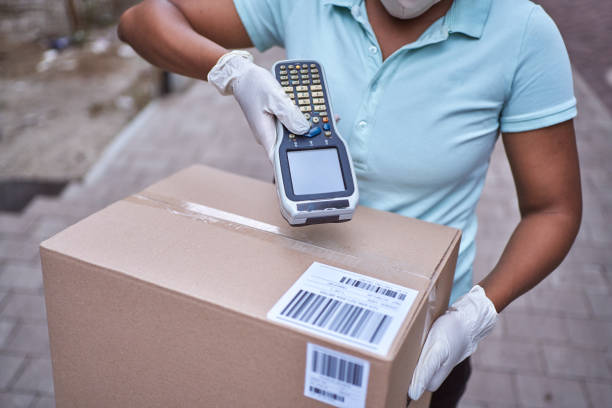 delivery woman black ethnicity scanning package barcode with bar code reader - bar code reader wireless technology computer equipment imagens e fotografias de stock