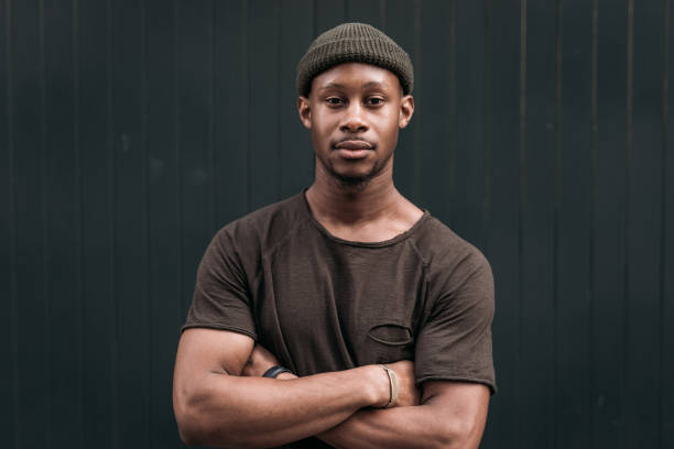 Millennial African man looking at camera with arms crossed stock photo