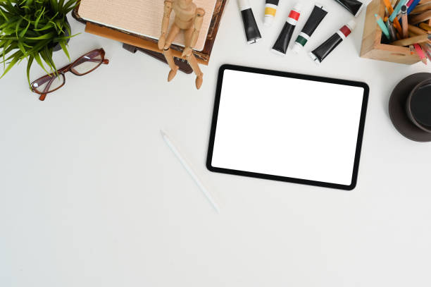 istock Top view of tablet with white screen on artist or designer work space. 1278551029