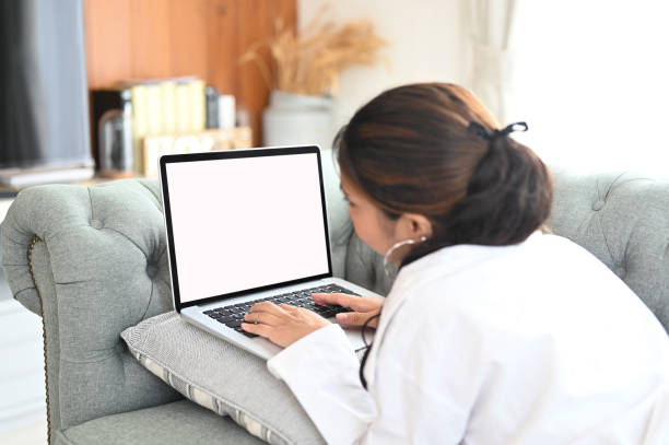 istock Young woman using laptop checking email news online, social networks or working on computer while laying on sofa. 1278551031