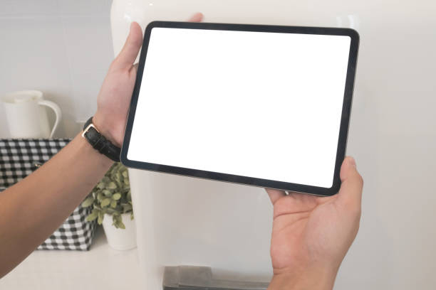 istock Cropped shot of hands holding digital labtop with blank screen in kitchen. 1278551463