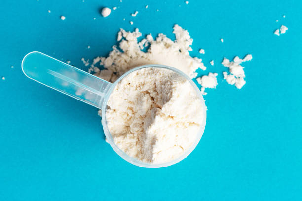 istock Scattered protein in scoop on blue background close-up, top view 1278551727