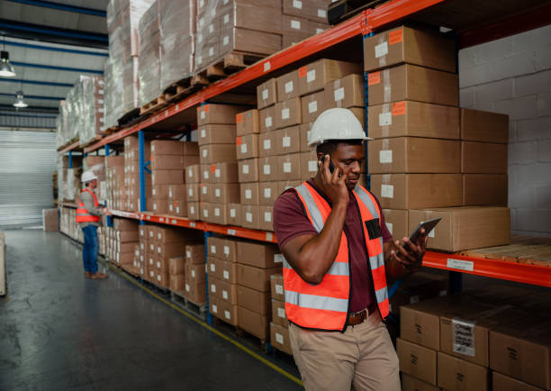 istock Stressed male worker talking on cellular device to boss while holding digital tablet in warehouse 1278551863