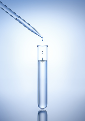 Test tube with pipette and droplets with reflecting blue background