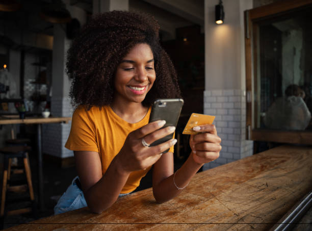 istock Female customer smiling while paying for delicious coffee in trendy cafe 1278554726
