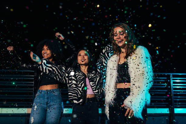 istock Three happy girls having fun under confetti on a roof 1278555591