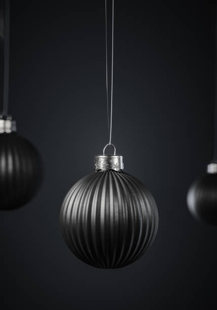 istock Vertically striped black Christmas balls hanging against dark gray background. 1278556418