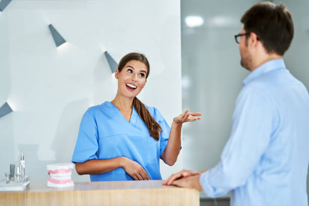 paciente pagando por visita dental en clínica - healthcare and medicine receptionist paying credit card fotografías e imágenes de stock