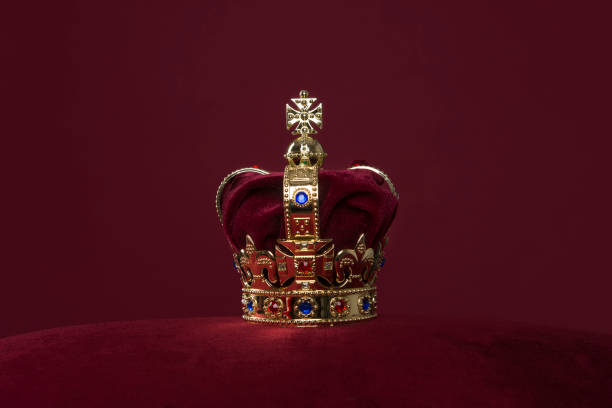 Golden crown on a velvet cushion on a deep red background with copy space Golden crown on a velvet cushion on a deep red background with copy space coronation photos stock pictures, royalty-free photos & images