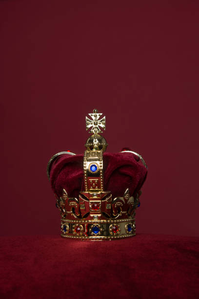 istock Golden crown on a velvet cushion on a deep red background with copy space in a vertical image 1278558868