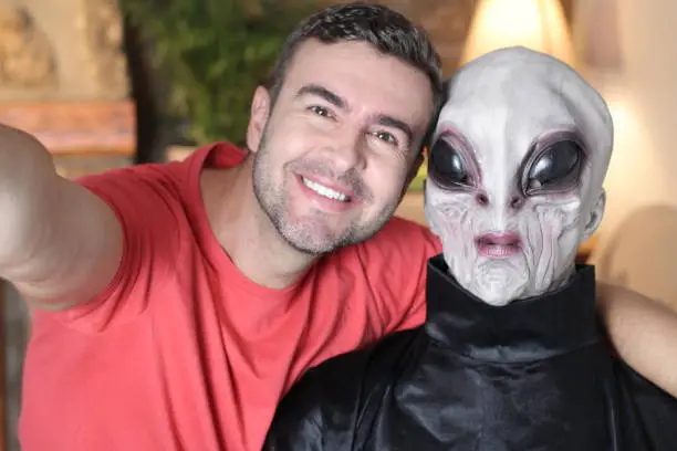 Photo of Man taking a selfie with funny looking alien