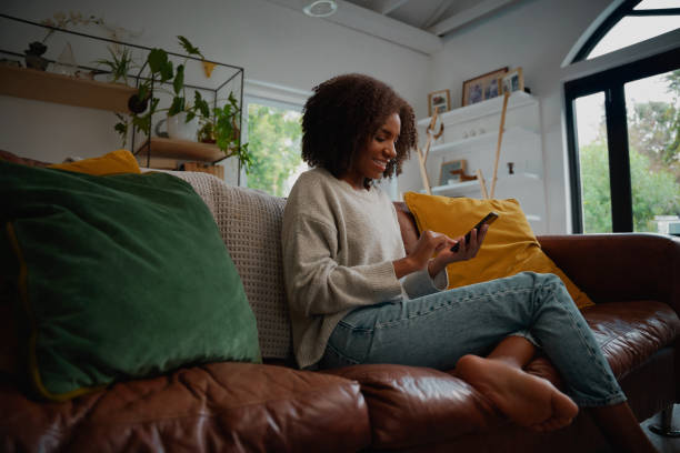 istock Woman resting at home using smartphone to send message sitting on sofa 1278562977