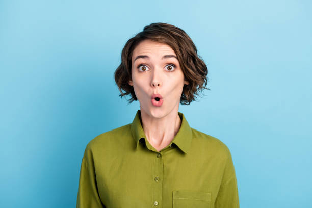 photo de portrait de l’étudiant féminin étonné choqué utilisant la coiffure ondulée courte mettant en vedette avec la bouche ouverte isolée sur le fond bleu de couleur - staring photos et images de collection