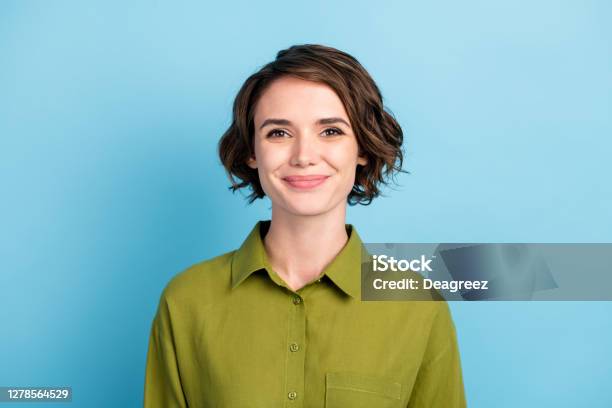 Photo Portrait Of Cute Smiling Pretty Girl With Brunette Short Hair Wearing Green Shirt Isolated On Blue Color Background Stock Photo - Download Image Now