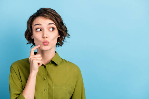 photo portrait of puzzled thoughtful dreamy female student trying to guess finding right solution thinking about idea isolated on blue color background with blank space - cheek color imagens e fotografias de stock