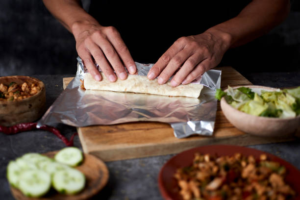 man preparing a durum or a burrito