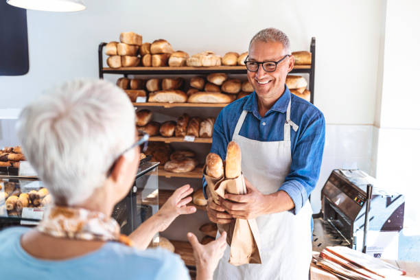 istock Female Client Buying Baguette From Salesman 1278569571