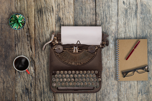 Old typewriter on a wooden desk.