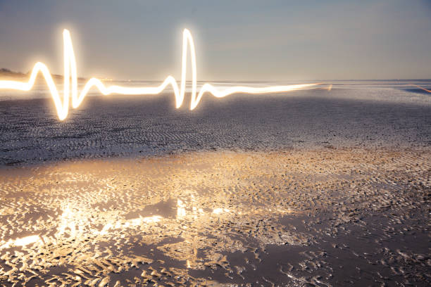 Light painting Light Painting Art: Luminous lifeline painted with a flashlight at the blue hour on the beach at low tide potential energy stock pictures, royalty-free photos & images