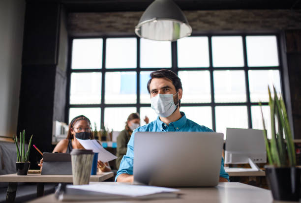 istock Business people with face masks indoors in office, back to work after coronavirus lockdown. 1278578021