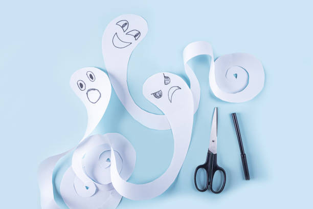 istock Halloween decorarion. Concept DIY and children creativity. Step-by-step instructions: making ghosts from white paper. Step 4 finished ghost figures 1278578466