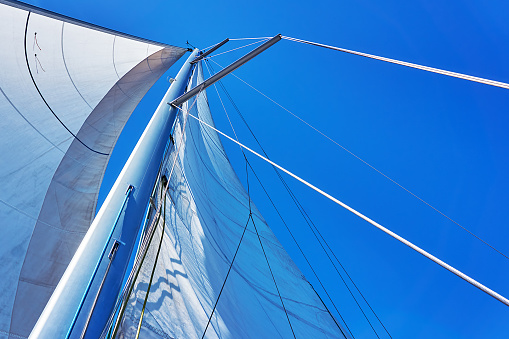 large white sail against a blue sky