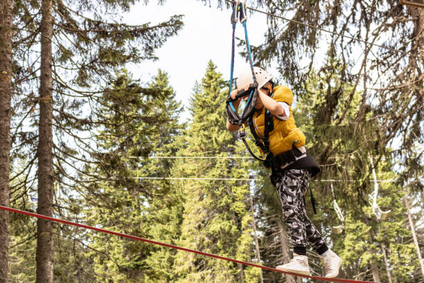 istock Little boy walking on a zip line while being on canopy tour in the forest. 1278579912