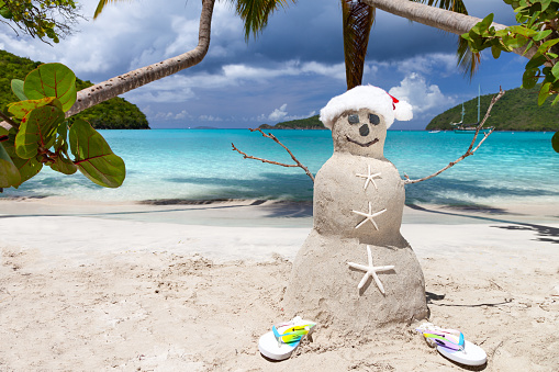 Snowman with Santa hat on tropical beach in the Caribbean, Maho Bay, St. John, United States Virgin Islands