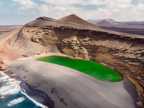 Photo of Volcanic crater with a green lake in El Golfo, Lanzarote, Spain. Aerial view