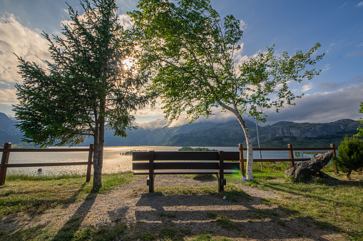 Photograph from the most beautiful bench in León, of the reservoir of Riaño in a day with sun and clouds over the mountains