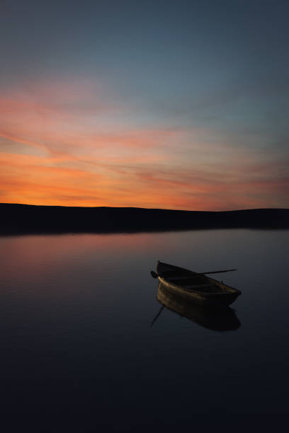 istock Boat on a calm lake at sunrise 1278585747