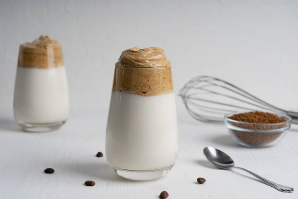 istock Sweet cold dalgona coffee with creamy topping on white wooden table at kitchen 1278588600