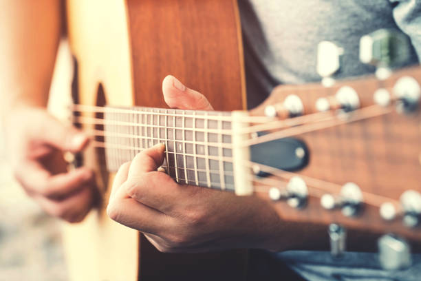 istock Man's hands playing acoustic guitar 1278590696