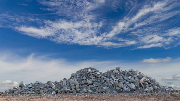 Large granite piles with sky clouds. A large granite pile like a mountain on the ground with a cloud of skies is a backdrop during the day. quarry photos stock pictures, royalty-free photos & images