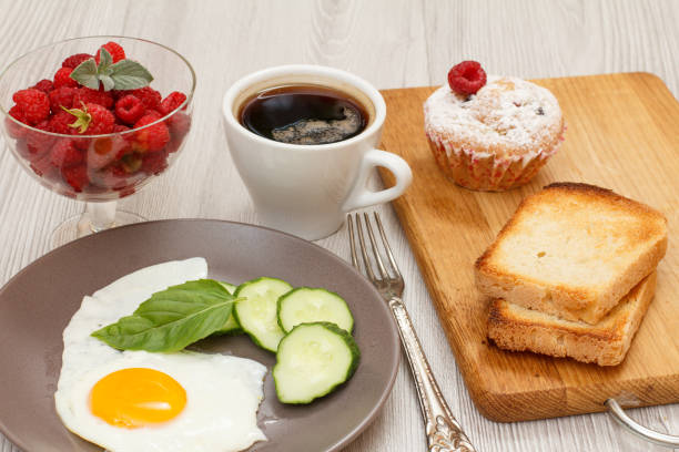 istock Plate with fried egg, cut cucumber and leaf of basil. Food set for breakfast 1278594373