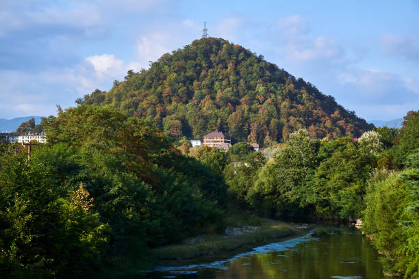 istock landscape with a hill, a river and a power transmission tower at the top 1278597741